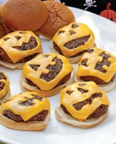 some hamburgers with cheese on them sitting on a plate