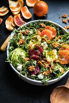 a salad with blood oranges, avocado and walnuts in a bowl