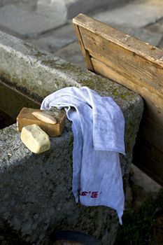 a white shirt is laying on the cement next to a wooden box and some rocks