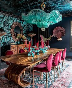 a dining room table surrounded by pink chairs and blue walls with an intricate design on the ceiling