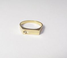 A 14k solid gold signet engagement ring with a diamond. This lovely minimal and clean designed signet ring is made of solid 14k gold and has a small diamond on one side (1.5 ct). The shiny diamond is set in a star designed inlay, which gives this ring yet more character and sparkle. This ring can be a great modern engagement ring or a high-class gift for any other happy occasion such as birthdays, births, anniversaries and more. This rin is great for everyday use - it is light and comfortable to 14k Gold Signet Ring With Tension Setting, Minimalist Diamond Signet Ring With Polished Finish, Minimalist Signet Ring With Tension Setting For Formal Occasions, Minimalist Formal Signet Ring With Tension Setting, Minimalist Signet Ring With Single Cut Diamonds, Minimalist Round Signet Ring With Single Cut Diamonds, Formal Minimalist Signet Ring With Tension Setting, Modern 14k Gold Signet Ring With Vvs Clarity, Modern Diamond Signet Ring As Gift