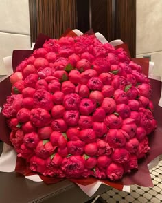 a large bouquet of red flowers sitting on top of a table