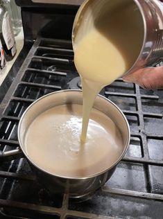 someone is pouring milk into a pan on the stove