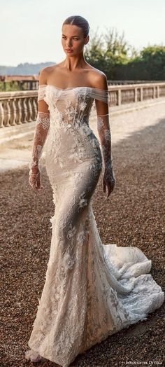 a woman in a wedding dress standing on the ground with her arms around her waist