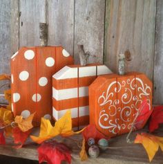 three wooden boxes decorated with fall leaves and pumpkins