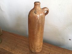 a brown vase sitting on top of a wooden table