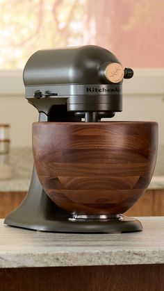 a kitchen aid mixer sitting on top of a counter next to a wooden cutting board