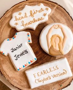 three decorated cookies sitting on top of a wooden plate