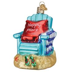 a glass ornament that says happy place with a blue chair and red pillow