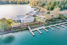 an aerial view of a house on the water with dock and docks in front of it