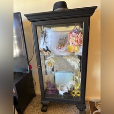 an old fashioned glass display case with many items in it's front and sides