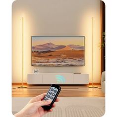 a person holding a remote control in front of a flat screen tv on a wall