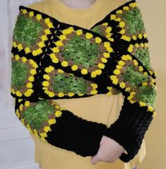 a woman wearing a yellow and black crocheted sweater