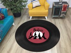 a round rug with the beatles silhouettes on it in a living room next to a yellow chair