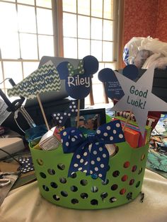 a green basket filled with lots of items on top of a table