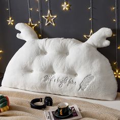 a white stuffed animal laying on top of a bed next to a cup and saucer