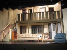 a stage set with couches, chairs and stairs