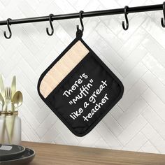 a pot holder hanging from a kitchen rack with utensils and spoons in it