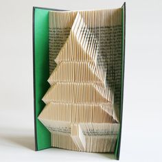 an open book with folded pages in the shape of a christmas tree