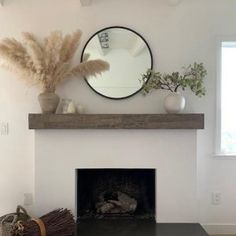 a living room with a fire place and mirror on the wall