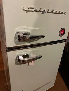 an old white refrigerator with chrome handles and the word frigga written on it