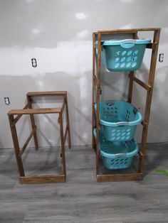 two blue baskets sitting next to each other on top of a wooden shelf in front of a wall