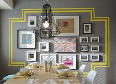 a dining room table with chairs and pictures on the wall in front of it,