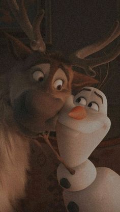 a close up of a person kissing a reindeer