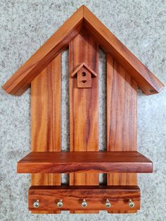 a wooden clock with a bird house on it