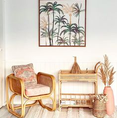 a living room with wicker furniture and palm trees on the wall above it,