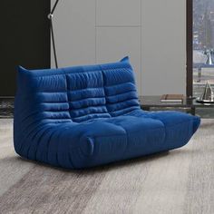 a blue couch sitting on top of a wooden floor