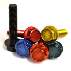 an assortment of screws and nuts on a white surface