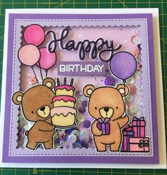 a handmade birthday card with two bears holding balloons and a cake on the table