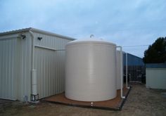 a large white water tank sitting next to a building