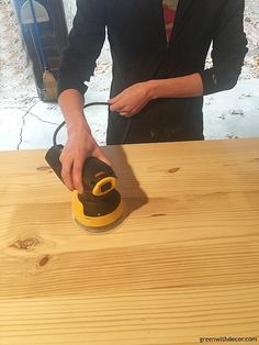 a man sanding wood with an electric sander