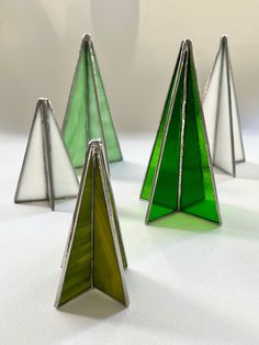 three green and white glass trees sitting on top of a table