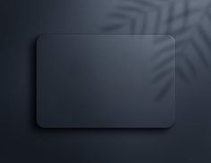 a black square button on a dark blue background with palm leaves in the back ground