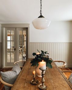 a dining room table with two candles on it