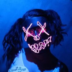 a woman wearing a neon mask with scissors on her face