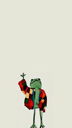 the frog is holding an apple in his hand and wearing a red, green, blue, and white sweater