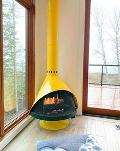 a yellow fire place sitting in the middle of a living room next to a window