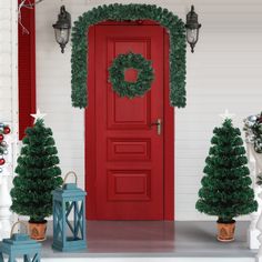 a red door with wreaths and christmas trees