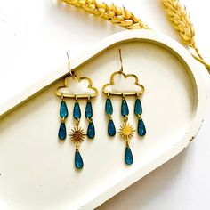 These unique cloud earrings are made from hand casted eco friendly resin with colourant, glitter and mica powder.  All of the components are brass apart from the hooks which are nickel free, gold plated, so they're perfect for sensitive skin.  Measuring approximately 3cm width x 7cm drop length, you don't need to worry about them being heavy...as resin is lightweight they're super comfortable.  ❤️ Your jewellery will arrive on a presentation card and wrapped in tissue. If your sending as a gift and want me to include a note from you, on plain card, just leave a message at checkout. If you'd prefer your message on a cute birthday card they're available for £2, here's the link - https://www.etsy.com/uk/listing/1128179895/birthday-card-available-when-bought-with?ref=shop_home_active_1&frs=1 G Raindrop Earrings, Cloud Earrings, Brass Jewellery, All That Glitters Is Gold, Presentation Cards, Cute Birthday Cards, Art Earrings, Gift Ideas For Her, Earring Cards