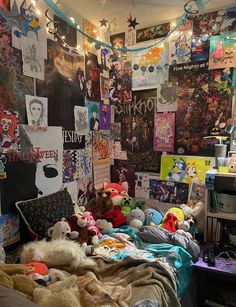 a messy bedroom with posters on the wall and stuffed animals all over the bed area