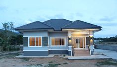 a small gray and white house sitting on top of a dirt field