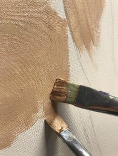 a paintbrush is being used to paint a wall with brown and white stripes on it