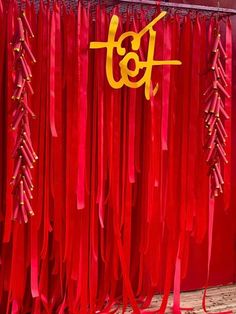 red curtains with gold letters and ribbons hanging from them