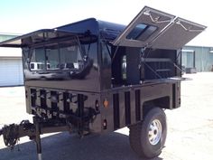 a black truck parked in a parking lot with its doors open and the roof down