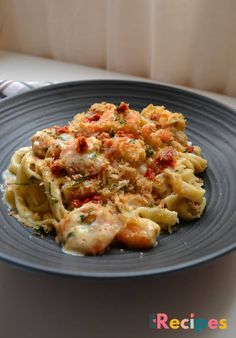 a blue plate topped with pasta covered in sauce