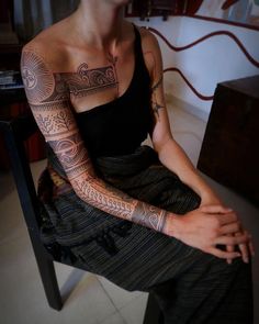 a woman with tattoos sitting on a chair